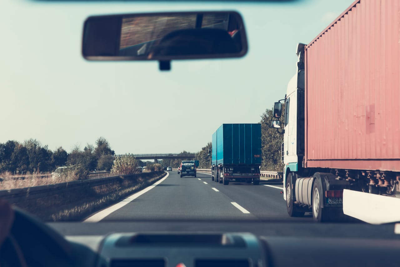 about-us View through rearview mirror of trucks on a German highway, driving towards Bamberg.